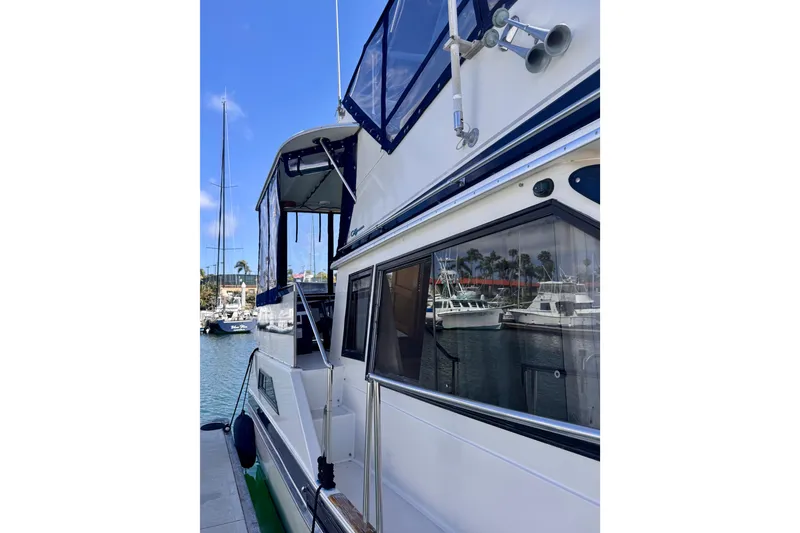 Slide: The Image of 1985 Californian 35 Motor Yacht docked at marina, showcasing sleek design and windows. - 13