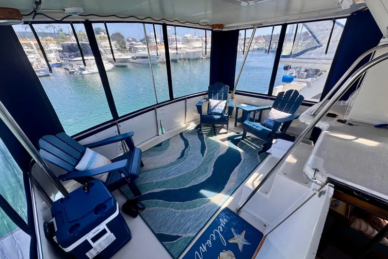 Slide: The Image of Californian 35 Motor Yacht 1985 interior with blue chairs and marina view. - 24