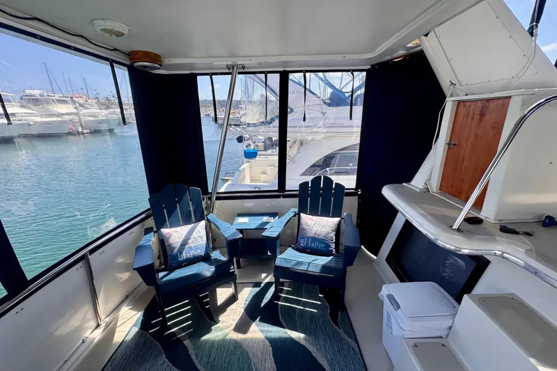 Slide: The Image of Interior of 1985 Californian 35 Motor Yacht with chairs and marina view. - 25