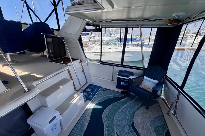 Slide: The Image of 1985 Californian 35 Motor Yacht interior with seating, cooler, and marina view. - 26