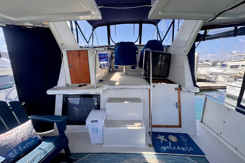 Slide: The Image of 1985 Californian 35 Motor Yacht interior with seating, steps, and marina view. - 27