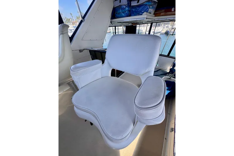 Slide: The Image of White captain's chair on 1985 Californian 35 Motor Yacht, with marina view. - 32