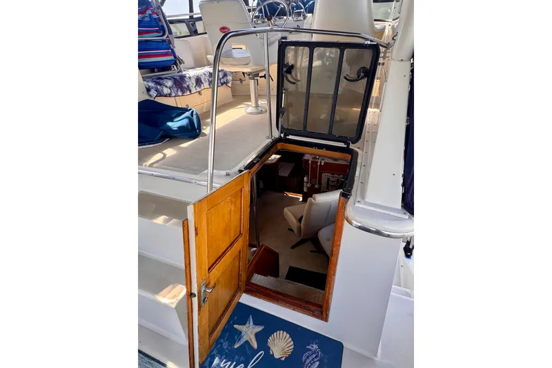 Slide: The Image of 1985 Californian 35 Motor Yacht interior view with open cabin door and seating area. - 44