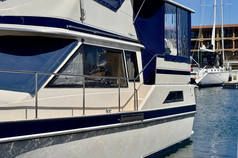 Slide: The Image of 1985 Californian 35 Motor Yacht docked in marina, featuring blue and white exterior. - 5