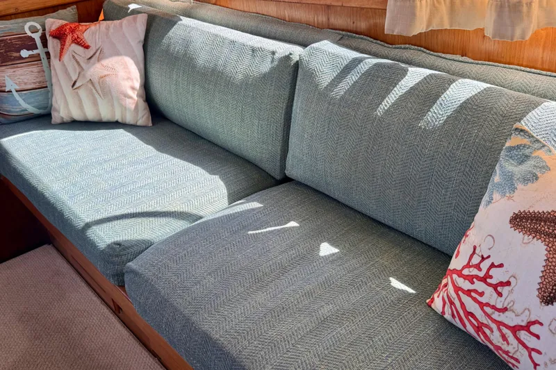 Slide: The Image of Interior of 1985 Californian 35 Motor Yacht with nautical-themed cushions on a cozy sofa. - 52