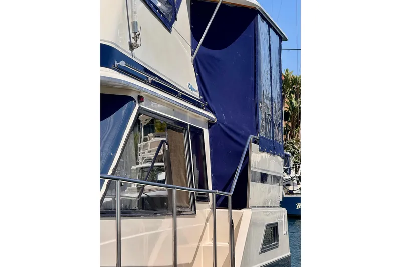 Slide: The Image of 1985 Californian 35 Motor Yacht with blue canopy docked at marina. - 6