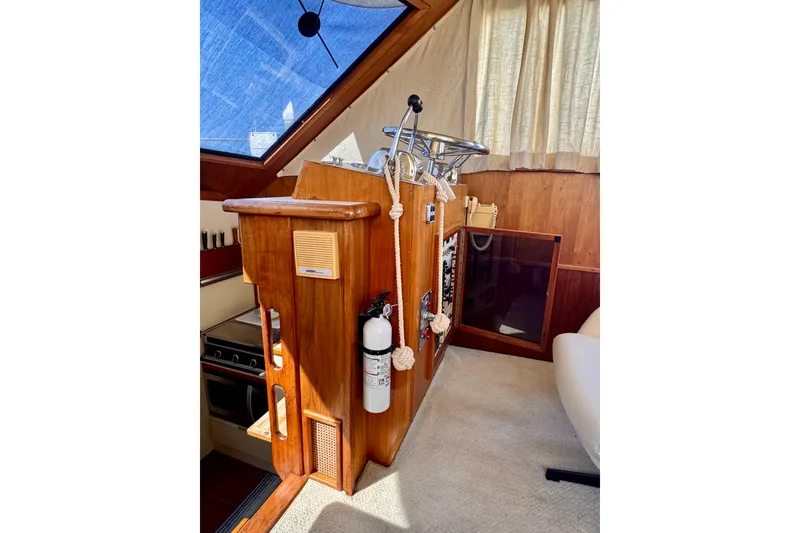 Slide: The Image of Interior helm of 1985 Californian 35 Motor Yacht with wooden paneling and nautical equipment. - 60