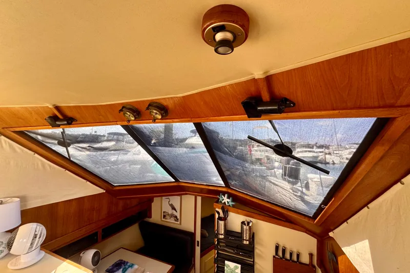 Slide: The Image of Interior view of 1985 Californian 35 Motor Yacht with large windows and wooden accents. - 61