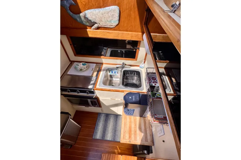 Slide: The Image of 1985 Californian 35 Motor Yacht kitchen with stove, sink, and wooden cabinetry. - 64