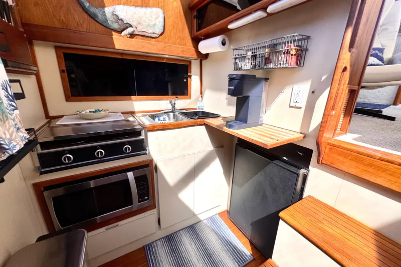 Slide: The Image of Compact kitchen in a 1985 Californian 35 Motor Yacht with stove, sink, and coffee maker. - 69