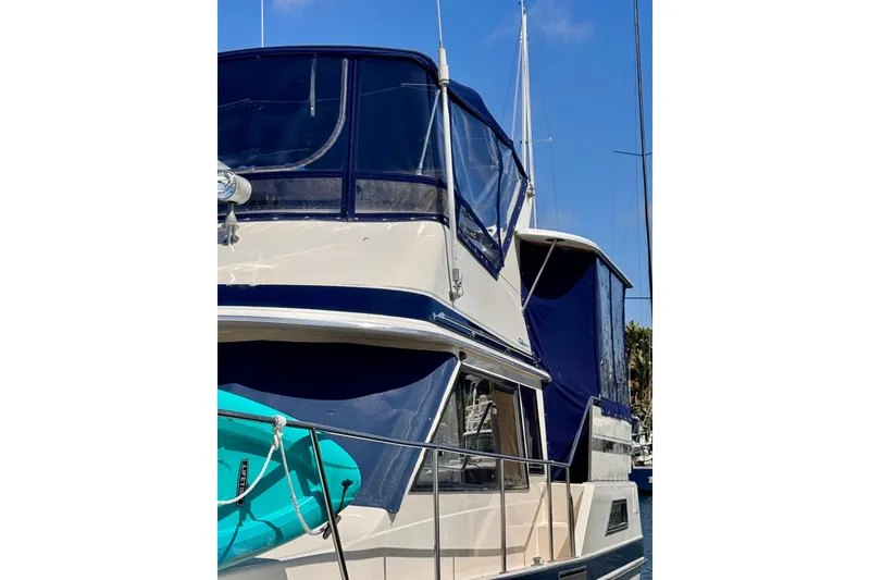 Slide: The Image of 1985 Californian 35 Motor Yacht with blue canopy docked in marina. - 7