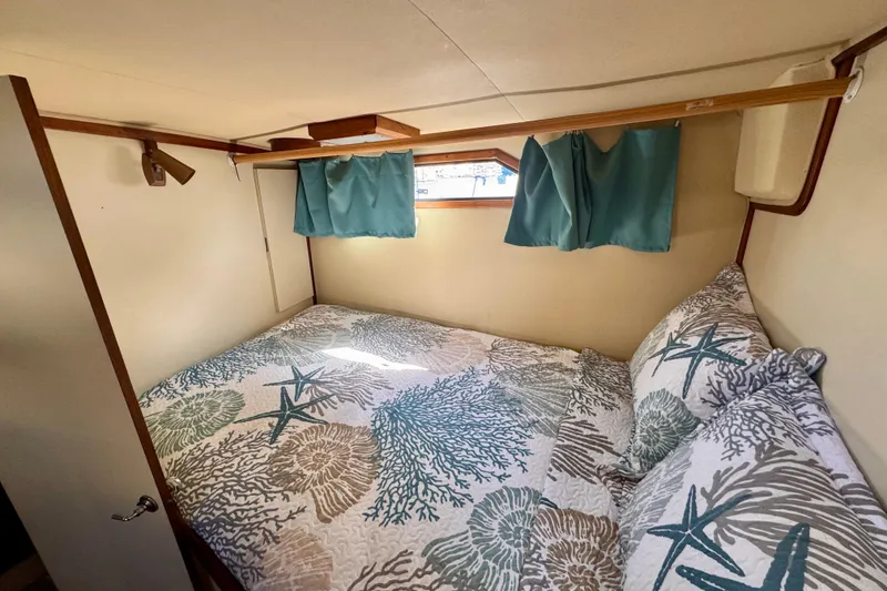 Slide: The Image of Cozy bedroom in 1985 Californian 35 Motor Yacht with nautical-themed bedding and teal curtains. - 77