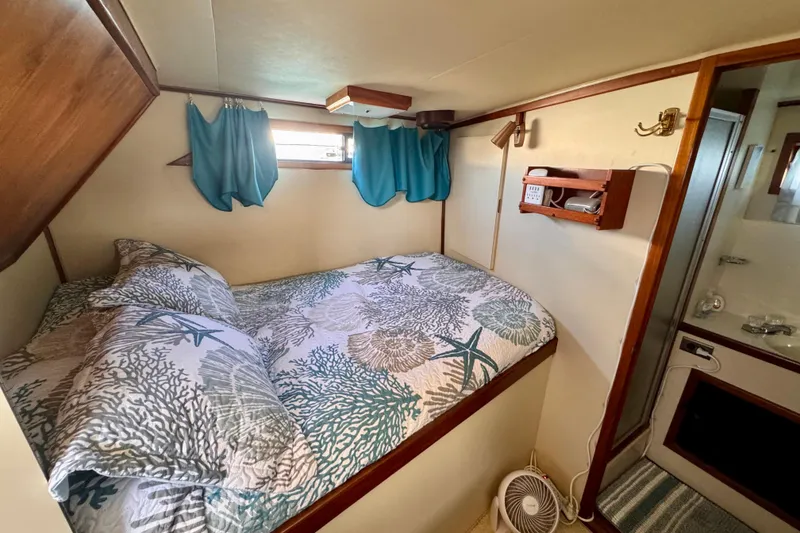 Slide: The Image of Cozy cabin interior of 1985 Californian 35 Motor Yacht with nautical-themed bedding. - 78