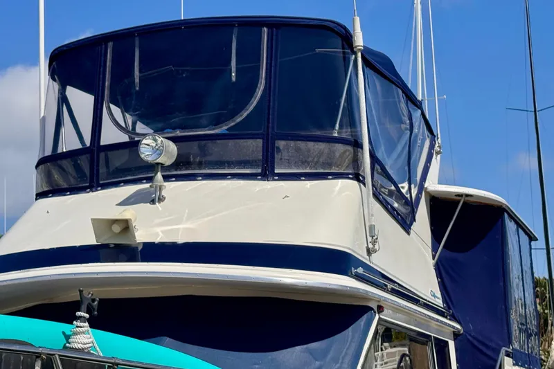Slide: The Image of 1985 Californian 35 Motor Yacht with blue canopy, docked under clear skies. - 8