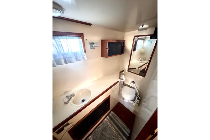Slide: The Image of 1985 Californian 35 Motor Yacht bathroom with sink, toilet, mirror, and window. - 80