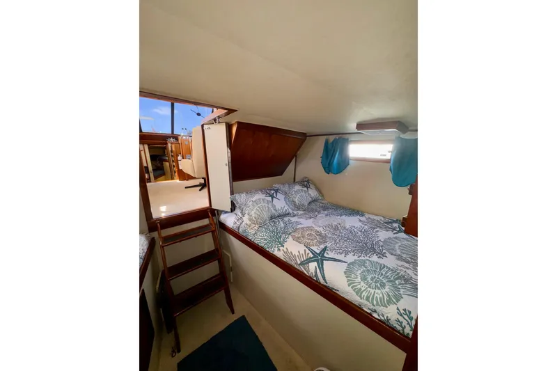 Slide: The Image of Cozy cabin interior of 1985 Californian 35 Motor Yacht with nautical-themed bedding. - 82