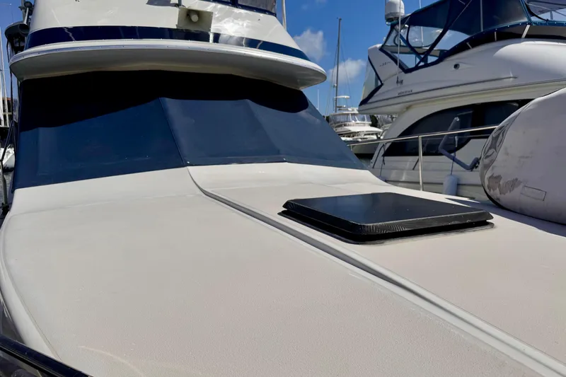 Slide: The Image of 1985 Californian 35 Motor Yacht docked, showcasing sleek design and spacious deck. - 9