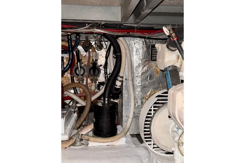 Slide: The Image of Engine room of 1985 Californian 35 Motor Yacht with visible hoses and machinery. - 92