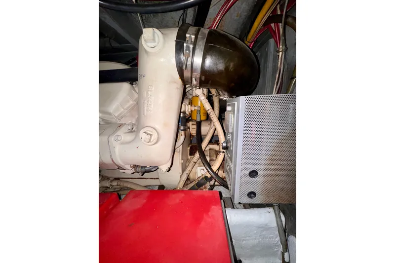 Slide: The Image of Engine compartment of a 1985 Californian 35 Motor Yacht, showcasing mechanical components and wiring. - 94