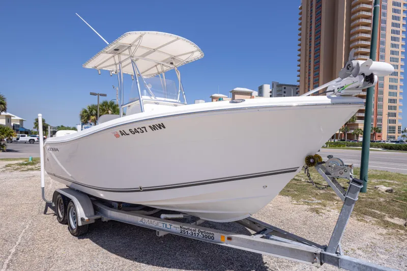 Slide: The Image of 2014 Cobia 214 Center Console boat on trailer, parked near tall buildings. - 13