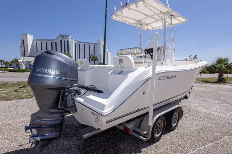 Slide: The Image of 2014 Cobia 214 Center Console boat with Yamaha engine on trailer, parked outdoors. - 15