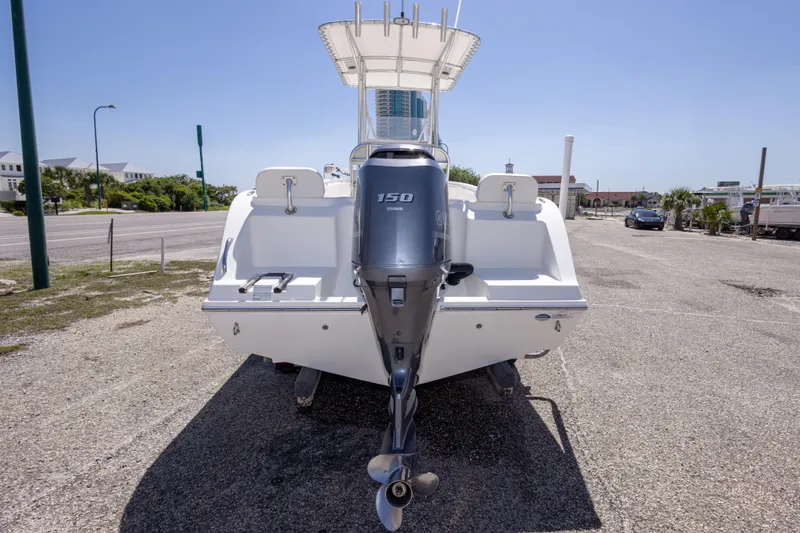 Slide: The Image of 2014 Cobia 214 Center Console boat with outboard motor in a parking area. - 16