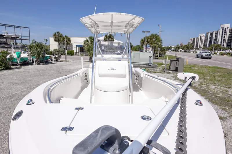 Slide: The Image of 2014 Cobia 214 Center Console boat parked near a road with palm trees. - 20