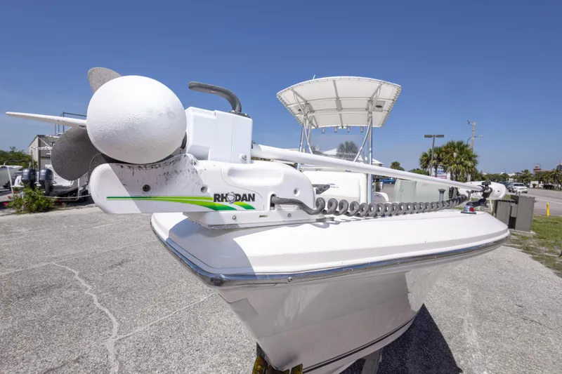 Slide: The Image of 2014 Cobia 214 Center Console boat with Rhodan trolling motor, parked outdoors. - 21