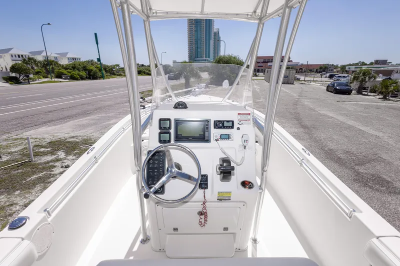 Slide: The Image of 2014 Cobia 214 Center Console boat dashboard with steering wheel and navigation equipment. - 24