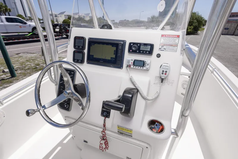 Slide: The Image of 2014 Cobia 214 Center Console boat dashboard with steering wheel and navigation equipment. - 31