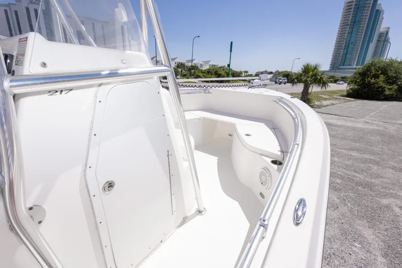 Slide: The Image of 2014 Cobia 214 Center Console boat with sleek design, docked near modern buildings. - 32