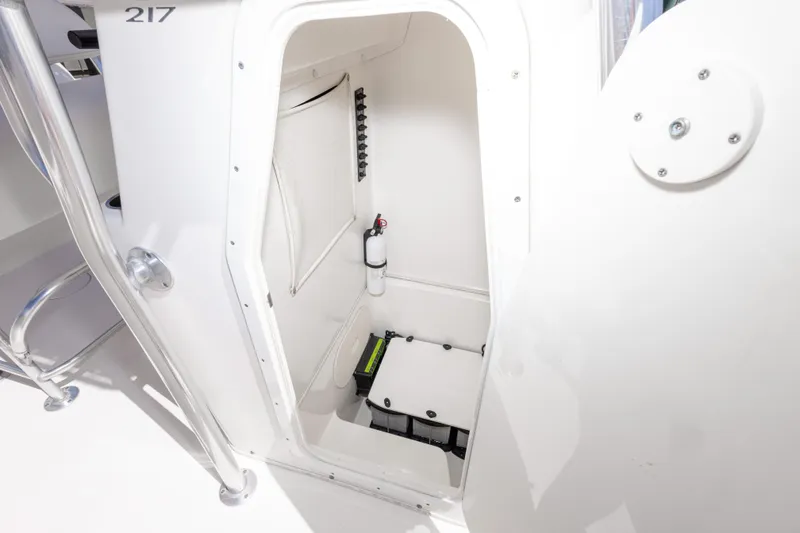 Slide: The Image of Interior storage compartment of 2014 Cobia 214 Center Console boat, featuring safety equipment. - 33