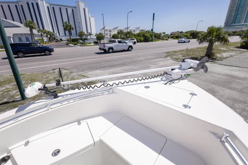 Slide: The Image of 2014 Cobia 214 Center Console boat with trolling motor, parked near a coastal road. - 36