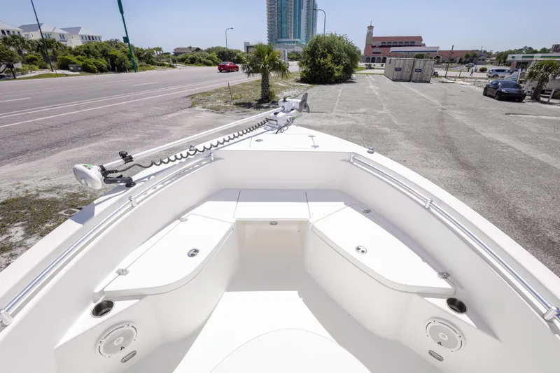 Slide: The Image of 2014 Cobia 214 Center Console boat parked near a road with buildings in the background. - 37