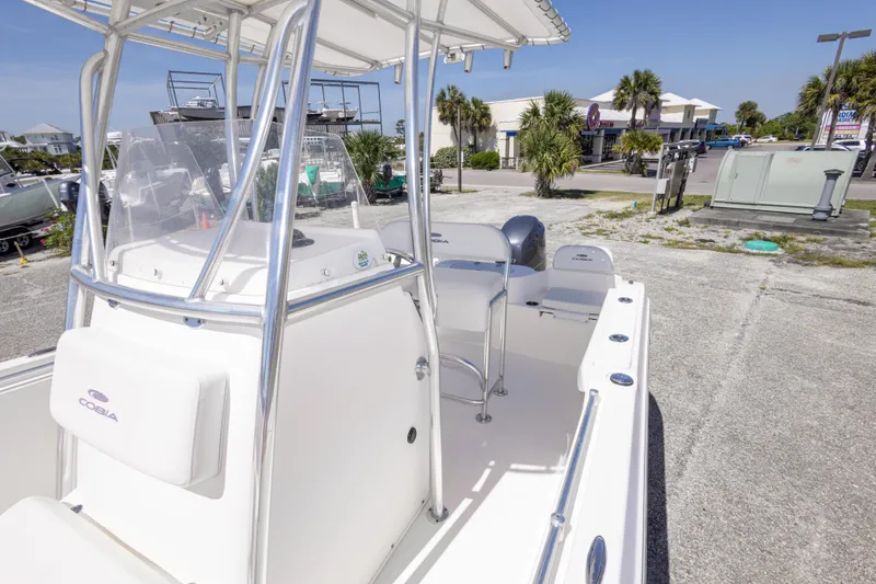 Slide: The Image of 2014 Cobia 214 Center Console boat with T-top, parked outdoors on a sunny day. - 39