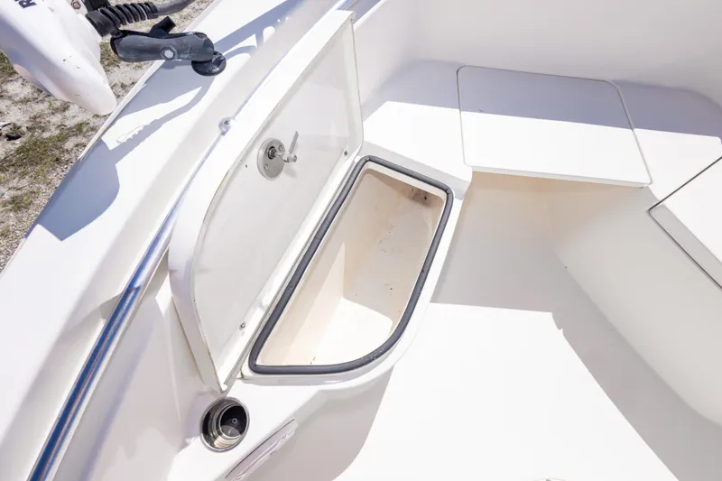Slide: The Image of 2014 Cobia 214 Center Console boat storage compartment open, showcasing interior space. - 44