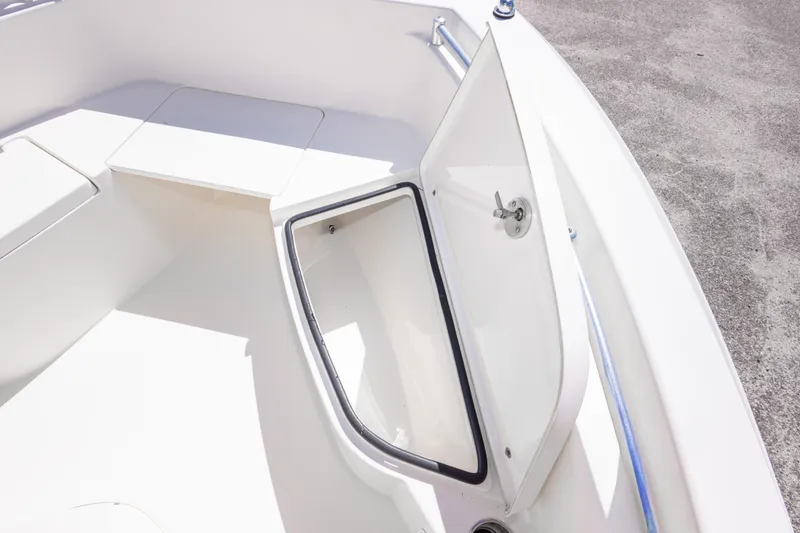 Slide: The Image of 2014 Cobia 214 Center Console boat with open storage compartment on deck. - 45