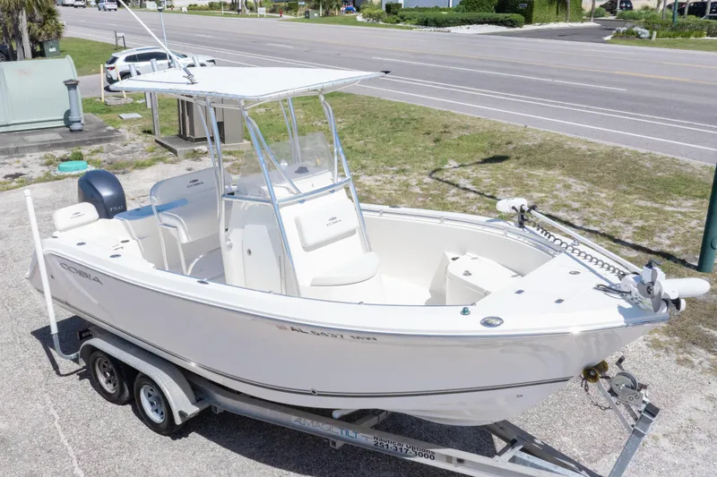 Slide: The Image of 2014 Cobia 214 Center Console boat on trailer, parked near a road. - 8