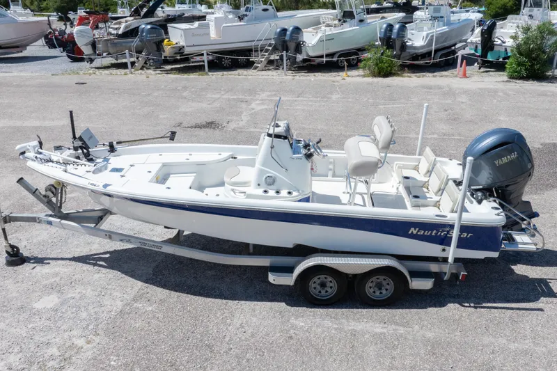 Slide: The Image of 2015 NauticStar 214 XTS boat on trailer, featuring Yamaha outboard motor. - 11