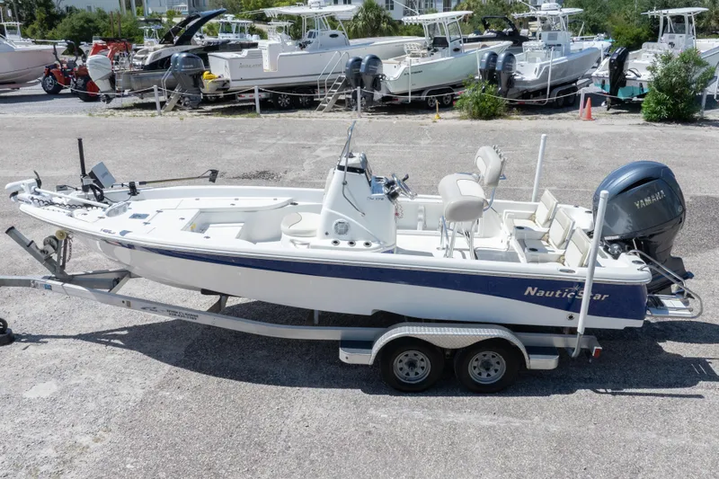 Slide: The Image of 2015 NauticStar 214 XTS boat on trailer, parked in marina lot. - 2