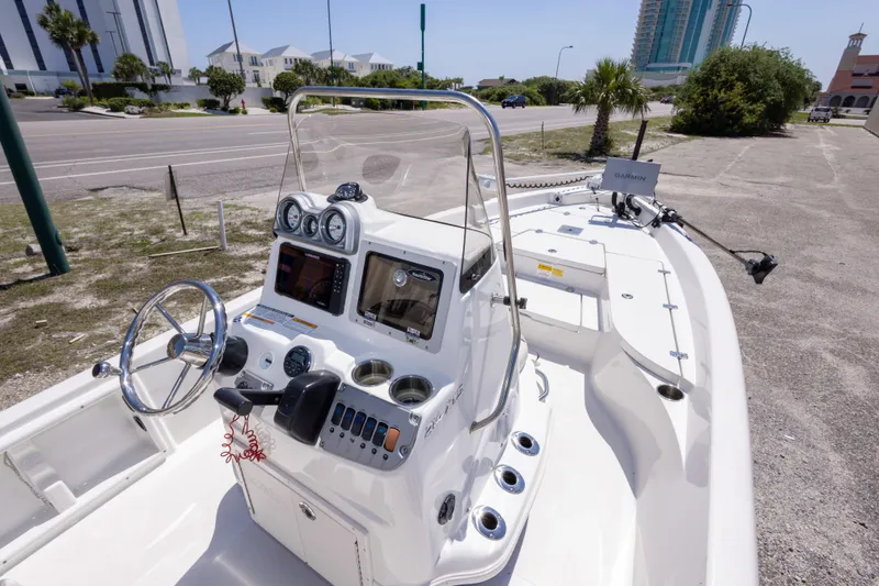 Slide: The Image of 2015 NauticStar 214 XTS boat with modern dashboard and steering, parked near a coastal road. - 28