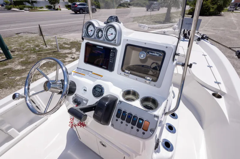 Slide: The Image of 2015 NauticStar 214 XTS boat dashboard with steering wheel and navigation instruments. - 31
