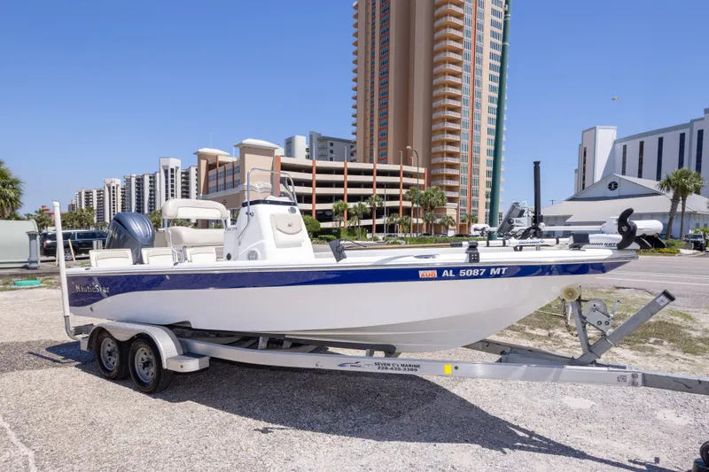 Slide: The Image of 2015 NauticStar 214 XTS boat on trailer, urban background with tall buildings. - 8