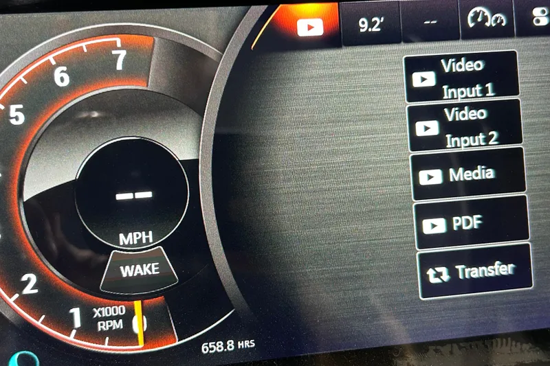 Slide: The Image of Dashboard display of a 2018 Sea Ray SLX-W 230, showing speedometer and media options. - 13