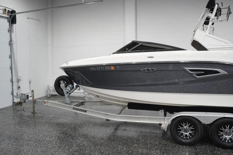 Slide: The Image of 2018 Sea Ray SLX-W 230 boat on trailer in garage setting. - 2