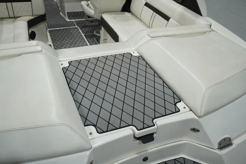 Slide: The Image of 2018 Sea Ray SLX-W 230 boat interior with white cushioned seating and diamond-patterned flooring. - 20