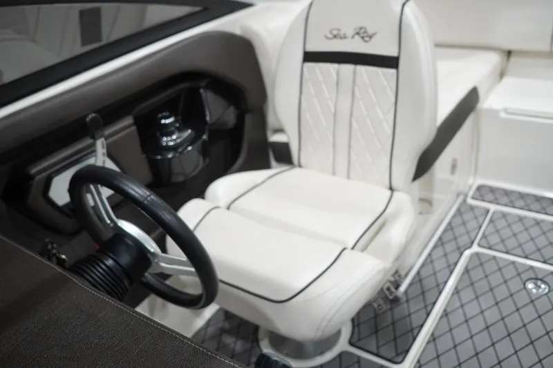 Slide: The Image of 2018 Sea Ray SLX-W 230 boat interior with white captain's seat and steering wheel. - 37