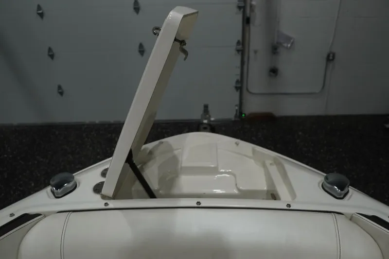 Slide: The Image of 2018 Sea Ray SLX-W 230 boat with open storage compartment in a garage setting. - 47