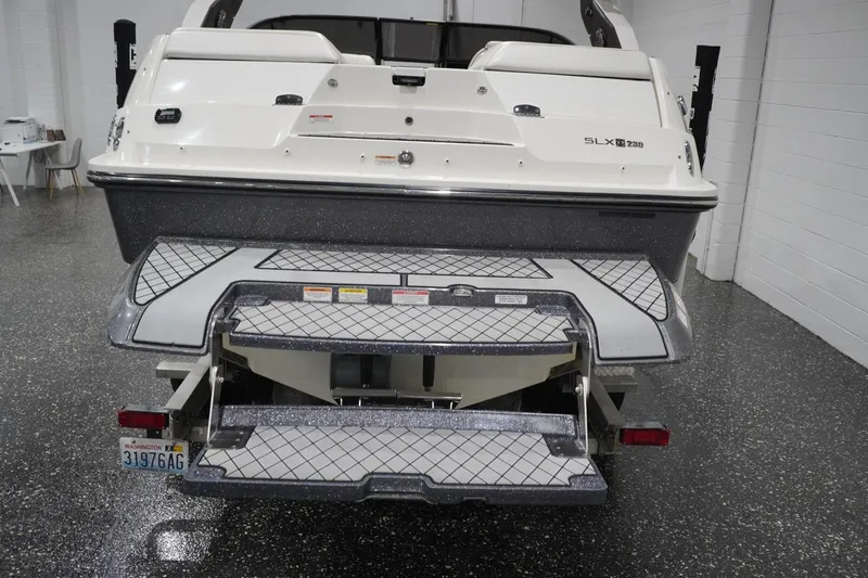 Slide: The Image of 2018 Sea Ray SLX-W 230 boat rear view in showroom with swim platform. - 5