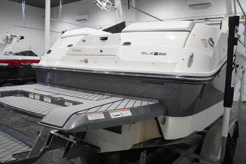 Slide: The Image of 2018 Sea Ray SLX-W 230 boat rear view in showroom setting. - 7